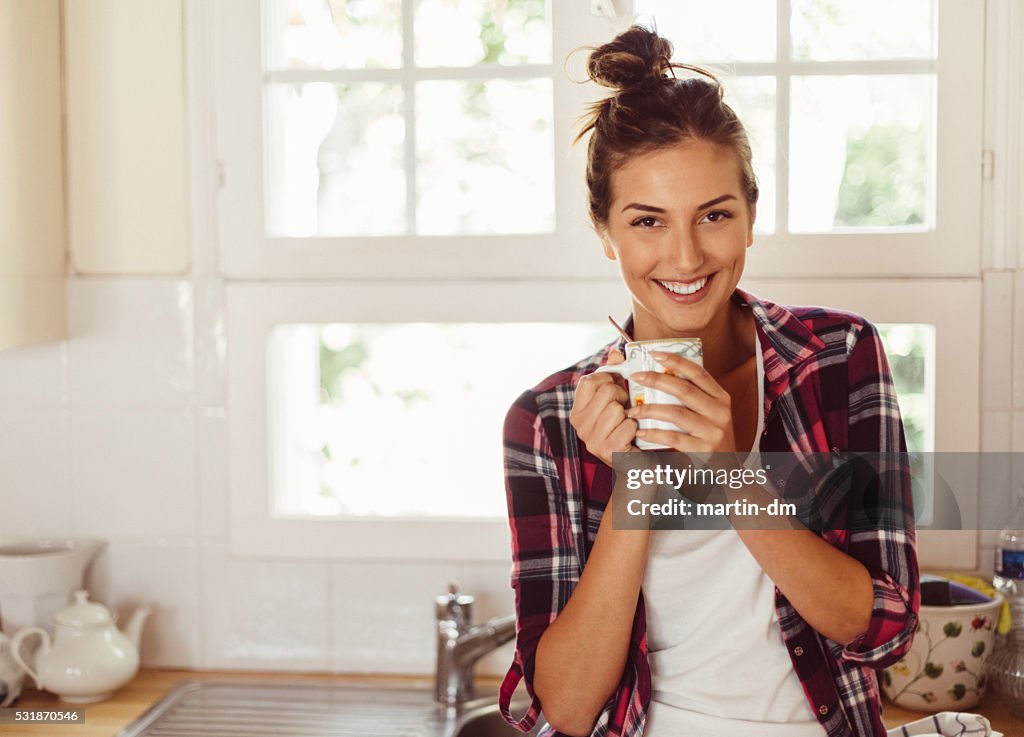 Smiling woman drinking coffee early in the morning