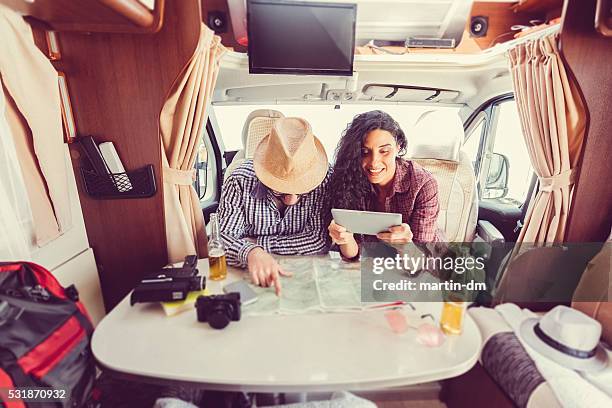 mid adult couple planning road trip in campervan - rv interior stock pictures, royalty-free photos & images