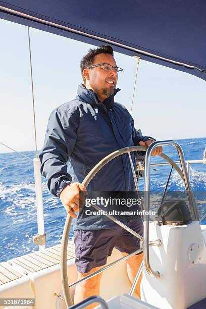 sailing  men skipper on a rudder of a sailboat - boat steering wheel stock pictures, royalty-free photos & images