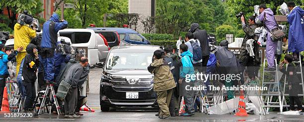 Media photographers and video crews surround as a car carrying suspect Kazuhiro Kiyohara leaves the Tokyo District Court on May 17, 2016 in Tokyo,...