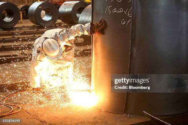An employee cuts a sample from a roll of coiled steel inside Liberty House Group's rolling steel mill in Newport, U.K., on Tuesday, May 17, 2016....