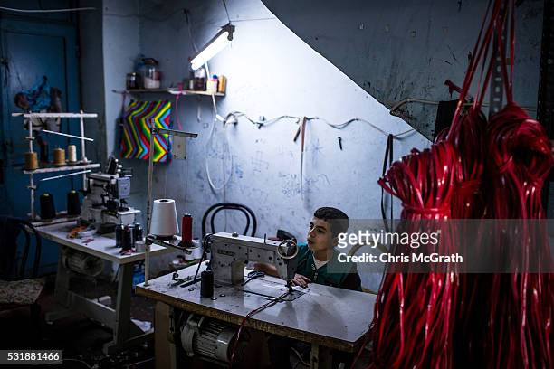 Syrian refugee boy makes shoe parts at a Turkish owned shoe workshop on May 16, 2016 in Gaziantep, Turkey. Since fleeing the war and after the new...