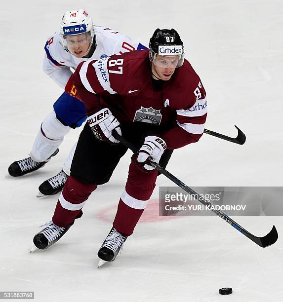 Norway's forward Ken Andre Olimb vies with Latvia's forward Gints Meija during the group A preliminary round game Latvia vs Norway at the 2016 IIHF...