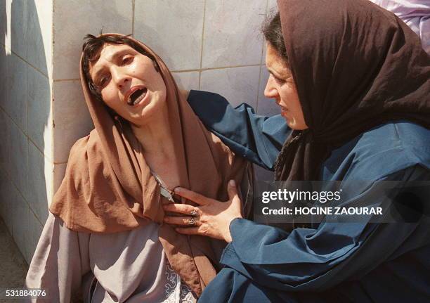 Distraught woman who has lost several close members of her family is comforted 23 September 1997 by a relative who lost her parents, at Zmirli...