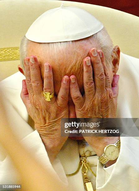 Pope John Paul II holds his head, in the courtyard of his summer residence in Castelgandofo, southeast of Rome, during his traditional weekly...