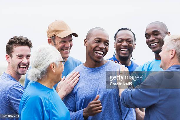african american man being congratulated by friends - people of different races stock pictures, royalty-free photos & images