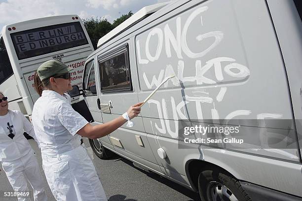 An anti-poverty activist paints the slogan "Long Walk to Justice" on a van before it joined busses and cars embarking to Edinburgh July 3, 2005 in...