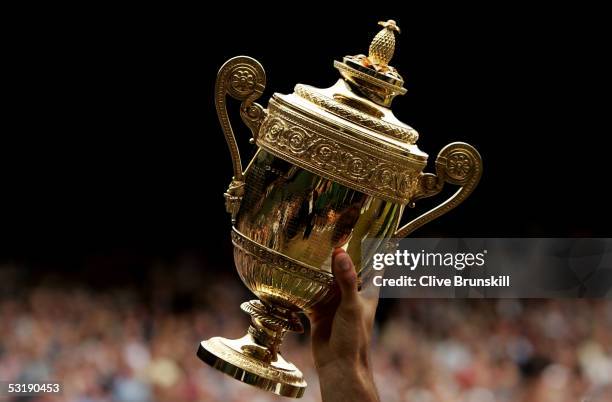 Roger Federer of Switzerland holds the trophy high after winning in straight sets against Andy Roddick of the USA in the Mens Singles final during...