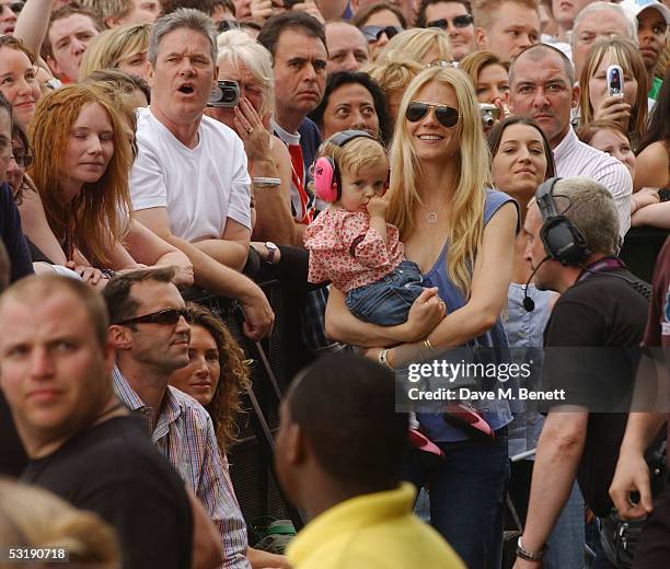 Actress Gwyneth Paltrow holds her daughter Apple as she watches the performances while DJ Johnny Vaughan and his wife Antonia look on during "Live 8...