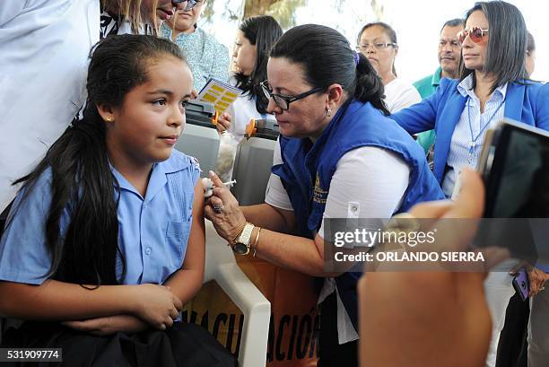 Girl is vaccinated against the human papilloma virus by Health Ministry employees in Tegucigalpa, on May 17, 2016. The government wants to inmunize...