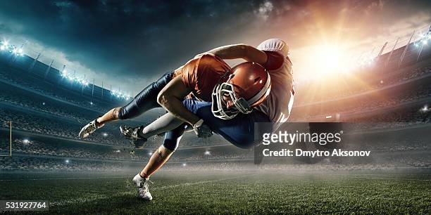 american football player being tackled - american football stock pictures, royalty-free photos & images