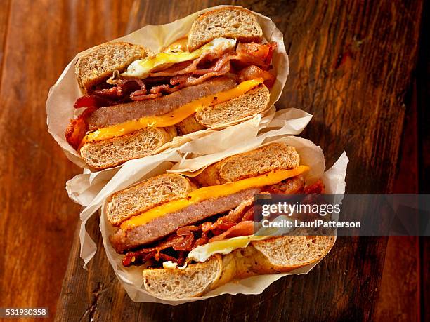 bagel, bacon, sausage and egg breakfast sandwich - breakfast eggs stockfoto's en -beelden