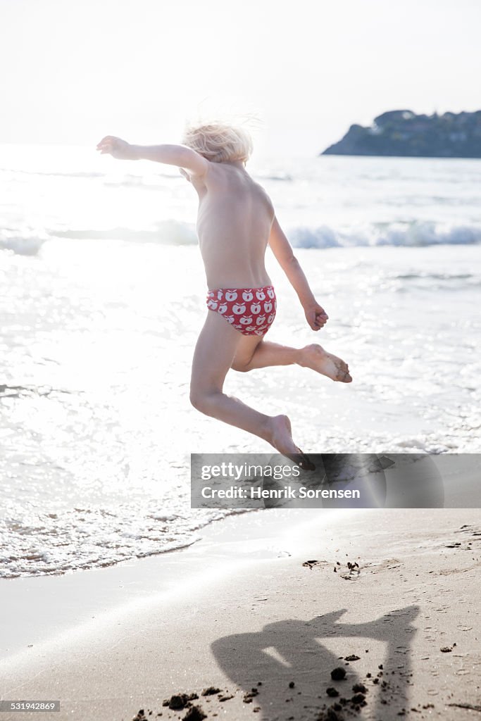 Boy jumping in the sand