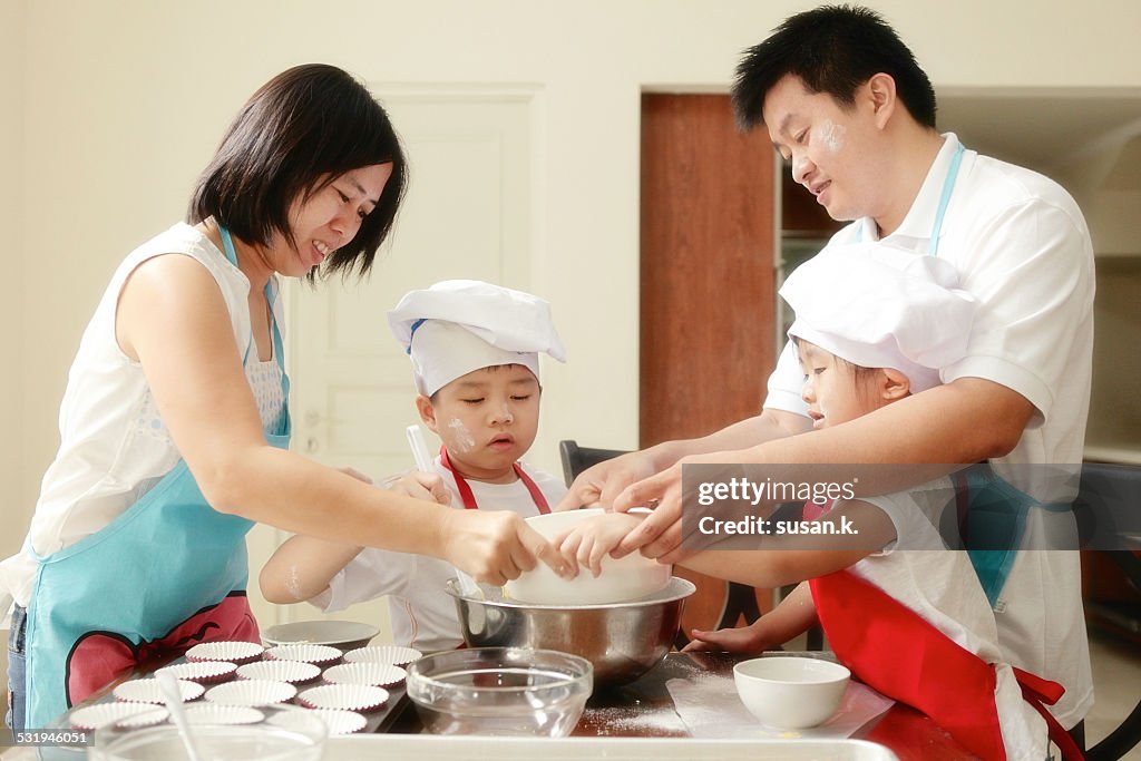 Family having fun baking muffin together