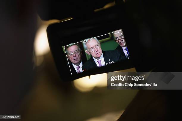 Senate Minority Leader Harry Reid , appearing in a television viewfinder, talks with reporters following the weekly Senate Democratic policy luncheon...