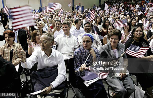 Some of the 290 people from 65 countries sworn in as U.S. Citizens wave flags after taking the Oath of Allegiance during the 17th annual Fiesta of...