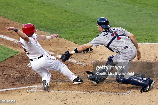 Adam Kennedy of the Los Angeles Angels of Anaheim is out at home plate by Joe Mauer of the Minnesota Twins in the 5th inning on July 4, 2005 at Angel...