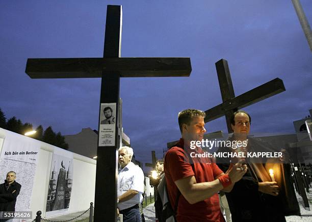 Demonstrators gather with candles at a memorial site at the former Checkpoint Charlie, early 05 July 2005 in Berlin, before the removal of the site...