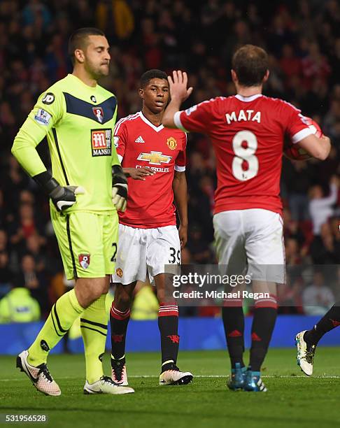 Adam Federici of Bournemouth looks dejected as Marcus Rashford of Manchester United celebrates with Juan Mata as he scores their second goal during...