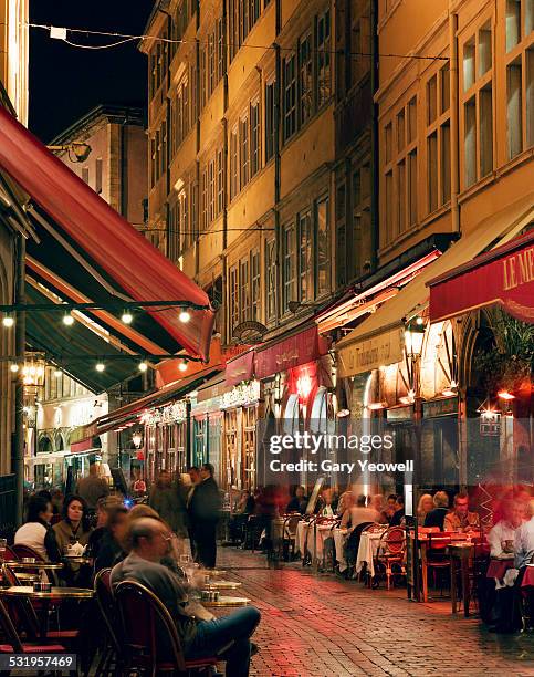 people dining outside in narrow street in lyon - lyon restaurants stock pictures, royalty-free photos & images