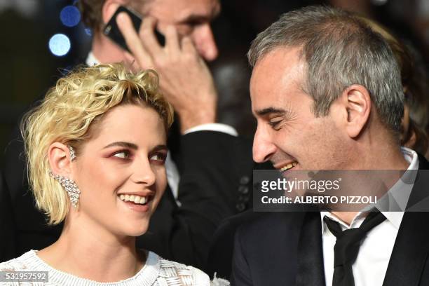 Actress Kristen Stewart looks at French director Olivier Assayas as they arrive on May 17, 2016 for the screening of the film "Personal Shopper" at...