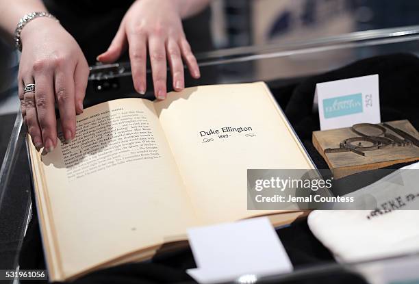 Curator displays a copy of the book "Famous Negro Music Makers" written and signed by author Langston Hughes which is one of the items from...