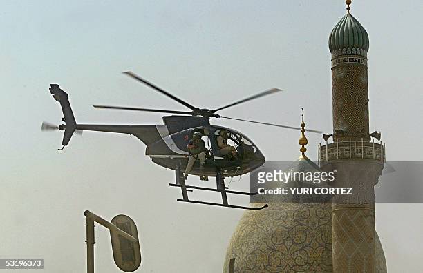 Helicopter of Blackwater security firm flies low above the scene where a roadside bomb exploded near the Iranian embassy in central Baghdad, 05 July...
