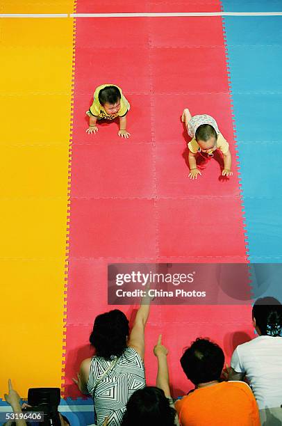 Babies crawl during a baby crawling race on July 5, 2005 in Shanghai, China. A recent survey carried out by Chinese medias shows that more than 60...