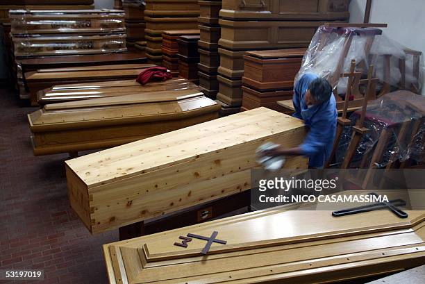 Worker polishes a "Wojtyla" model cypres coffin in a firm in the central Italian town of Cesena 05 July 2005. The coffin-maker has been advertising...