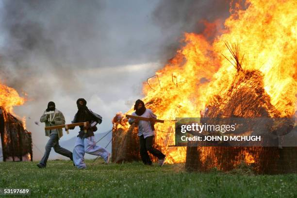 Auchterarder, UNITED KINGDOM: Darfur survivors re-enact the destruction of their homes by the Janjaweed militia and Sudanese Army near Gleneagles,...