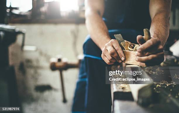 carpenter scraping wood with planer - carpentry stockfoto's en -beelden