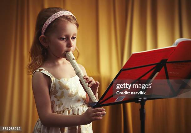 pouco hábil menina tocando flauta - flauta imagens e fotografias de stock