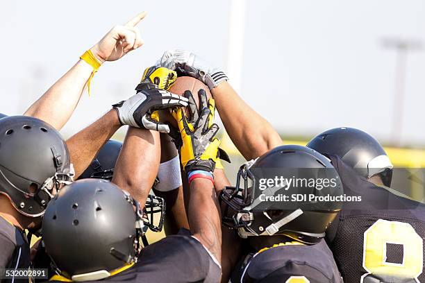 professional football players holding ball on sidelines at stadium - american football player celebrating stock pictures, royalty-free photos & images