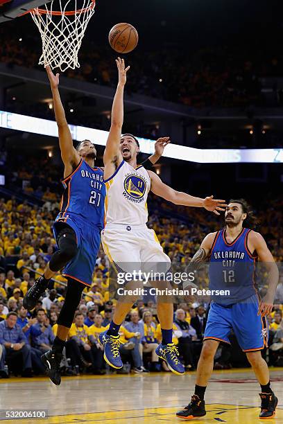 Klay Thompson of the Golden State Warriors lays up a shot past Andre Roberson of the Oklahoma City Thunder during game one of the NBA Western...