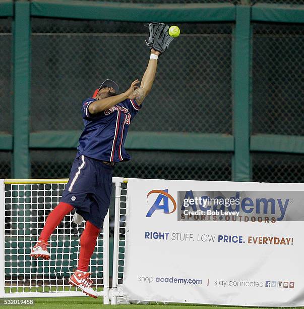 Eddie Pleasant of the Houston Texans leaps at the fence but is unable to make a catch during the JJ Watt Charity Softball Classic at Minute Maid Park...