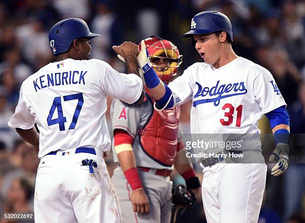 Joc Pederson of the Los Angeles Dodgers celebrates his two run homerun with Howie Kendrick in front of Geovany Soto of the Los Angeles Angels, to...