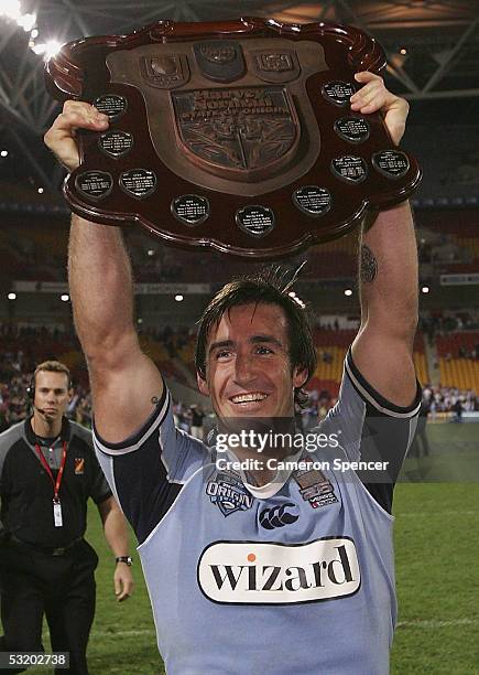 Andrew Johns of the Blues holds up the trophy after winning game three of the ARL State of Origin series between the Queensland Maroons and the New...