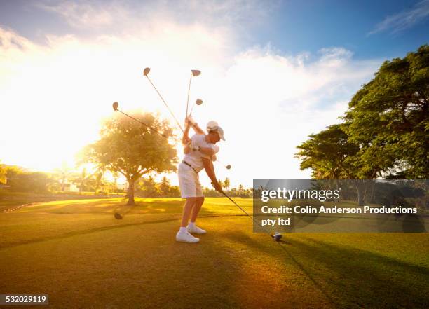 multiple exposures of caucasian golfer hitting ball on course - golf swing sequence stock pictures, royalty-free photos & images