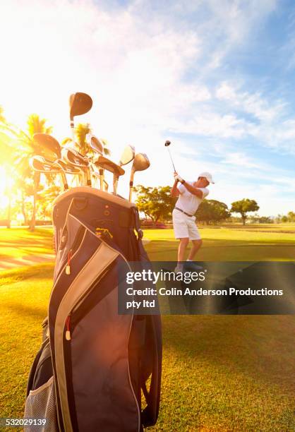 caucasian golfer hitting ball on golf course - solo un uomo anziano foto e immagini stock