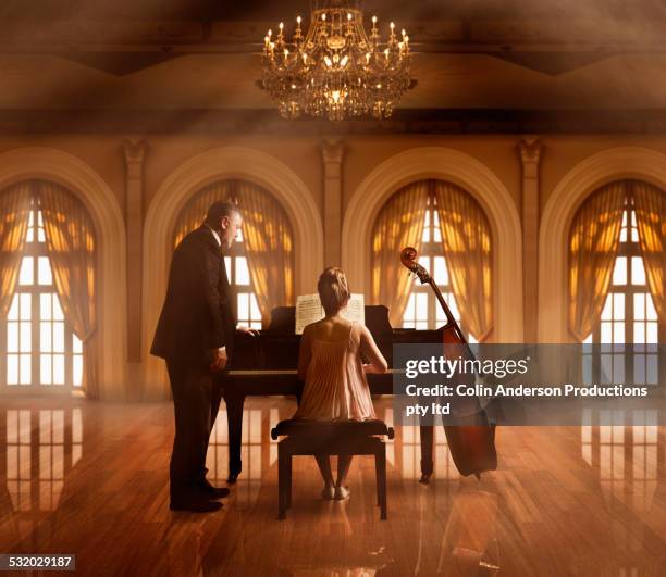 caucasian music teacher and student at piano in ballroom - fabolous musician stock pictures, royalty-free photos & images