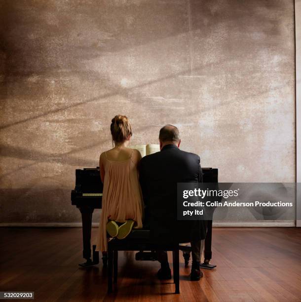 caucasian music teacher and student playing piano - デュエット ストックフォトと画像