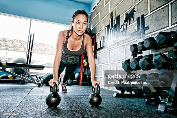 mixed race woman exercising in gym - push up japanese stock-fotos und bilder