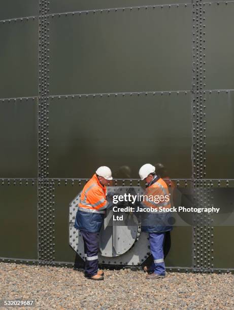 caucasian technicians examining fuel storage tank - vehicle hatch stock pictures, royalty-free photos & images