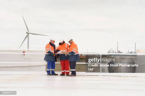 caucasian technicians talking on fuel storage tank - quality control inspectors stock-fotos und bilder