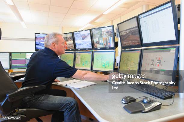 caucasian security officer monitoring screens in control center - gesture control screen imagens e fotografias de stock