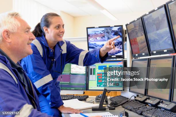 security officers monitoring screens in control center - diversity people industry stock-fotos und bilder