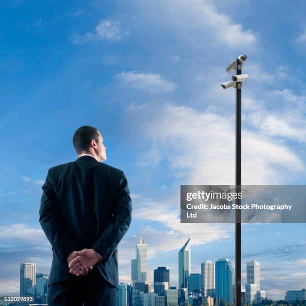 asian businessman admiring perth city skyline, western australia, australia - hands behind back stock photos et images de collection