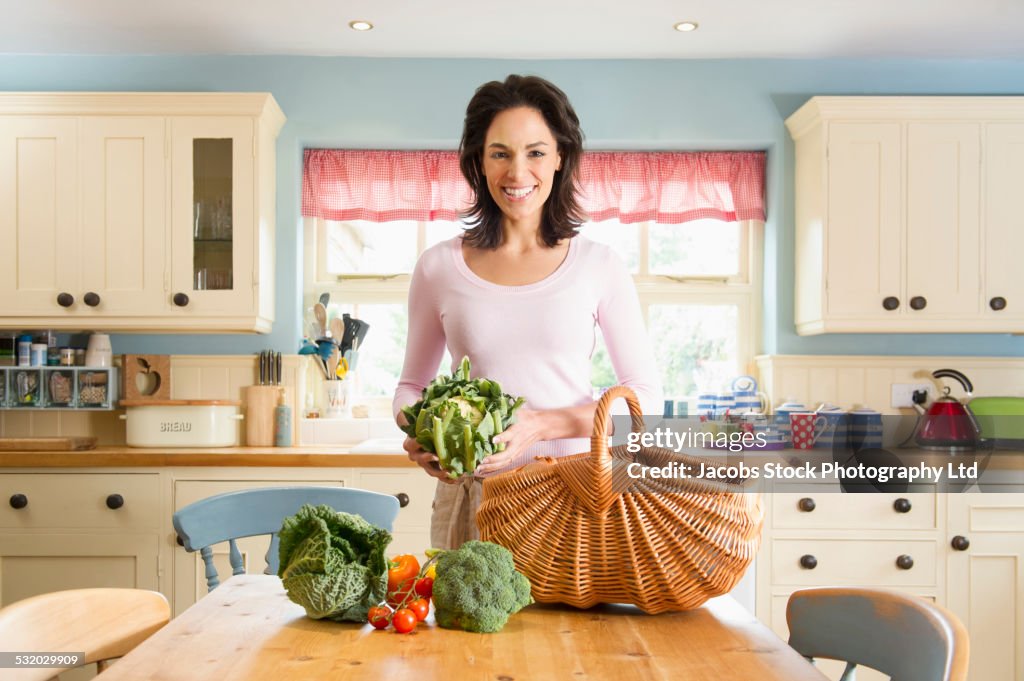 Hispanic woman unpacking produce groceries in kitchen