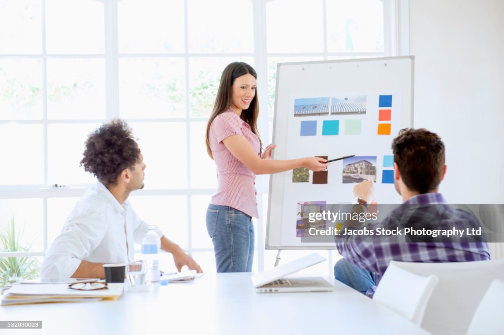 Businesswoman giving presentation to colleagues in conference