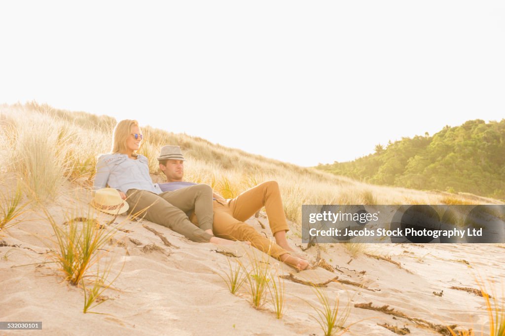 Caucasian couple relaxing together on beach